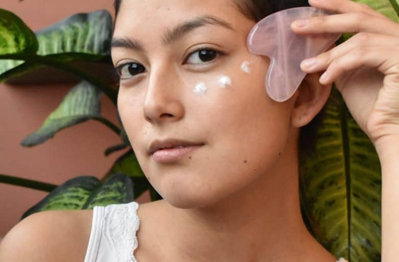 a woman holding a piece of plastic in front of her face